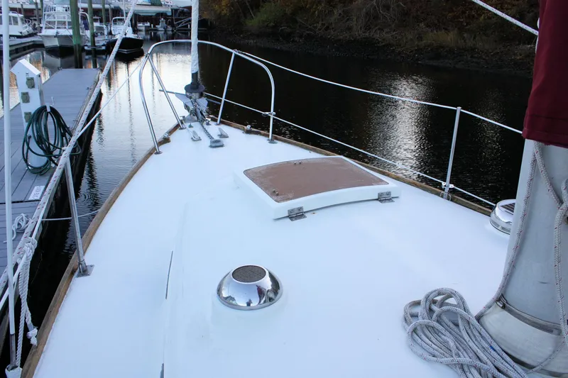 Slide: The Image of 1976 Bristol 34 sailboat deck with ropes and hatch, docked by calm water. - 22
