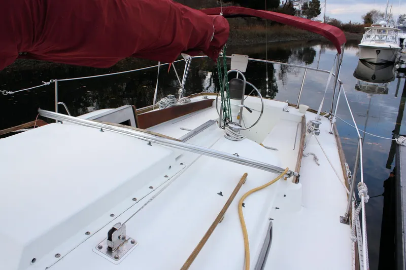 Slide: The Image of 1976 Bristol 34 sailboat with red sail cover, docked in calm waters. - 25