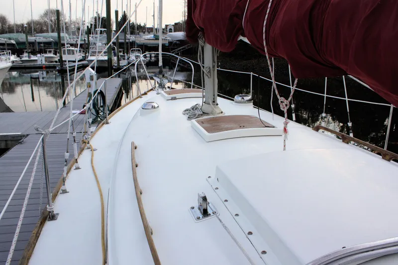 Slide: The Image of 1976 Bristol 34 sailboat deck with red sail, docked at marina. - 27