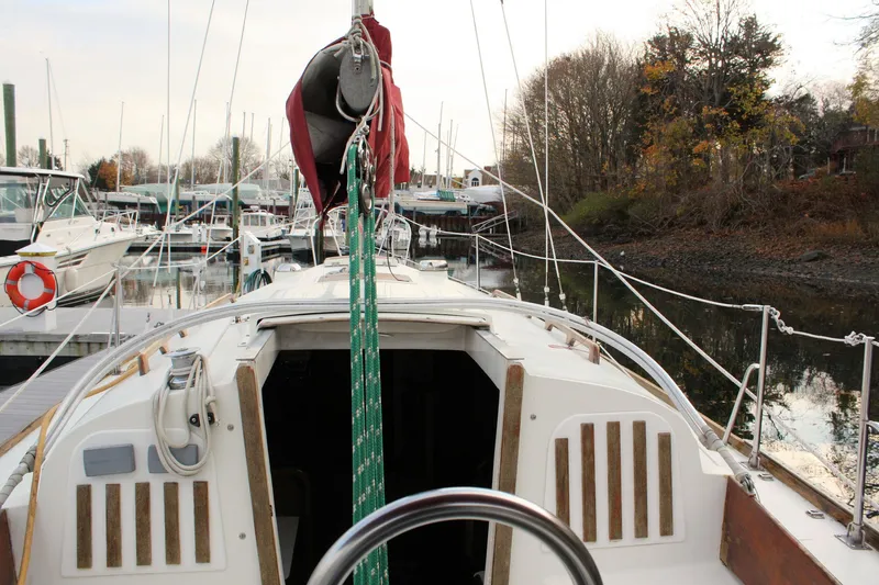 Slide: The Image of 1976 Bristol 34 sailboat docked in a serene marina setting. - 28