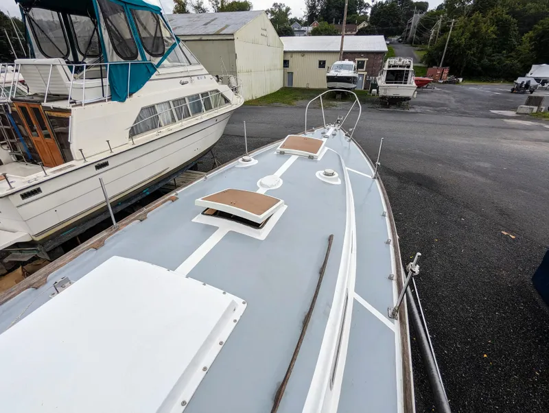 Slide: The Image of 1976 Bristol 34 sailboat on land, surrounded by other boats and buildings. - 3