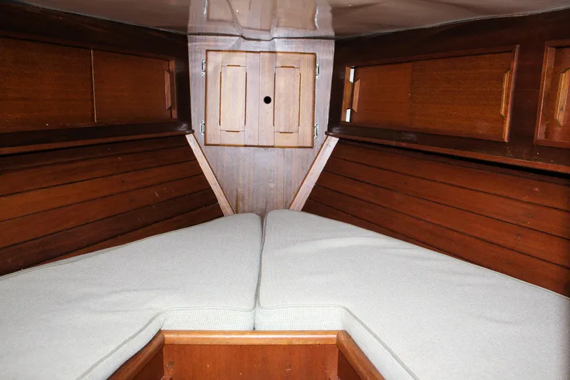Slide: The Image of Interior cabin of a 1976 Bristol 34 sailboat with wooden paneling and cushioned seating. - 31