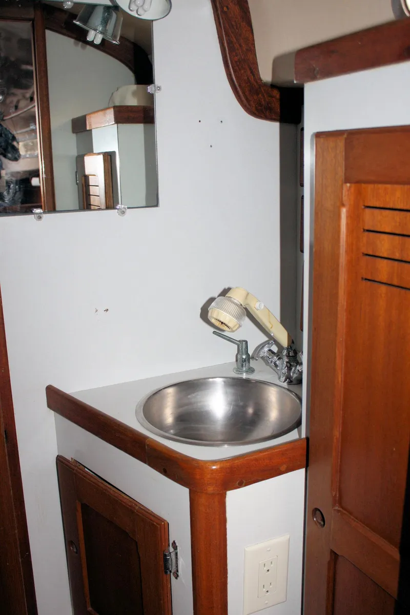 Slide: The Image of 1976 Bristol 34 yacht bathroom with sink, mirror, and wooden cabinetry. - 33