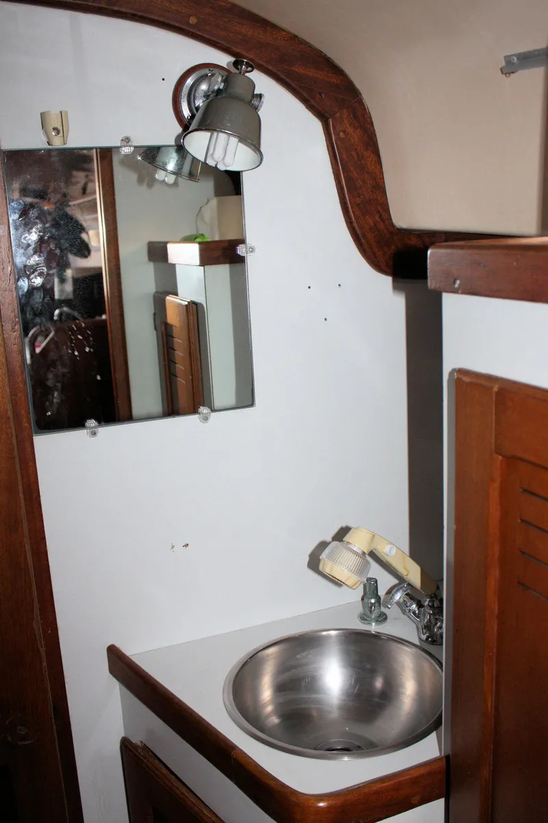 Slide: The Image of 1976 Bristol 34 yacht bathroom with sink, mirror, and wooden accents. - 34