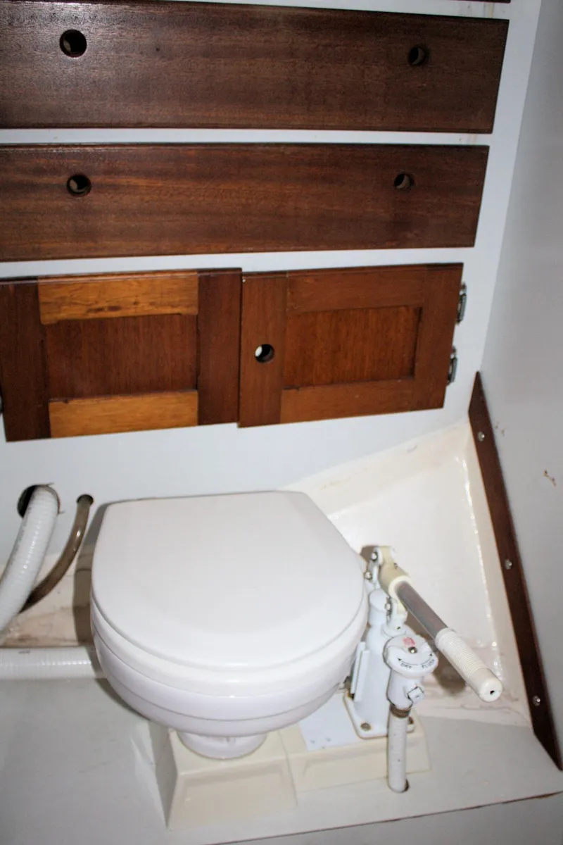 Slide: The Image of 1976 Bristol 34 yacht bathroom with wooden cabinets and marine toilet. - 35