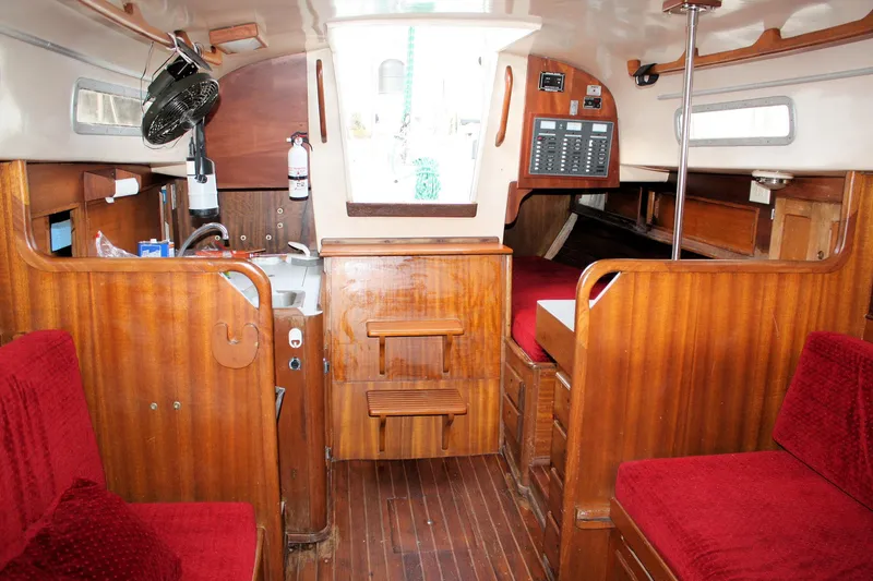 Slide: The Image of Interior of a 1976 Bristol 34 sailboat with wooden finishes and red seating. - 39