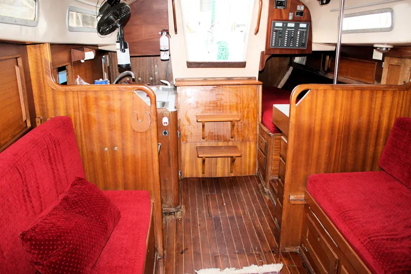 Slide: The Image of Interior of a 1976 Bristol 34 sailboat with red cushions and wooden finishes. - 40