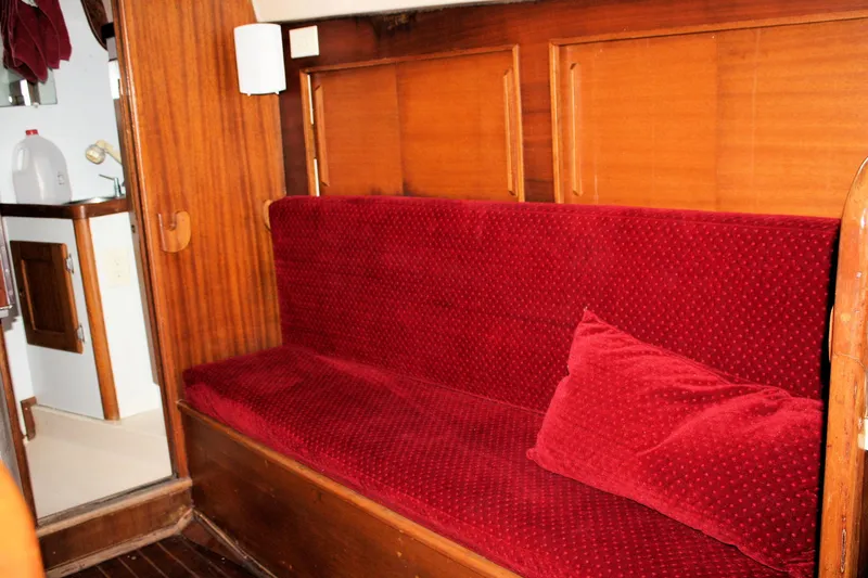 Slide: The Image of 1976 Bristol 34 yacht interior with red cushioned seating and wooden paneling. - 41