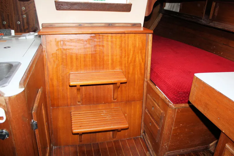 Slide: The Image of 1976 Bristol 34 yacht interior with wooden steps and red cushioned seating. - 48
