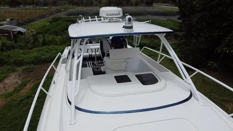Slide: The Image of 2008 Intrepid 390 Sport Yacht with Garmin equipment, docked in a lush, green setting. - 15