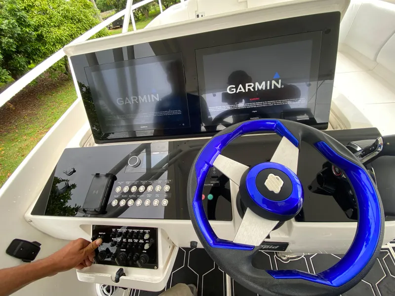 Slide: The Image of Control panel of a 2008 Intrepid 390 Sport Yacht with Garmin displays and blue steering wheel. - 18