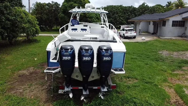 Slide: The Image of 2008 Intrepid 390 Sport Yacht with triple 350 engines, parked on grass near a house. - 37