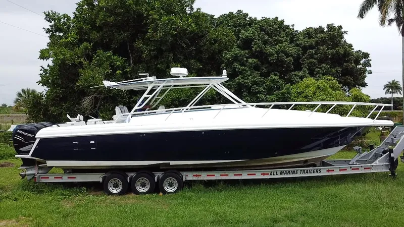 Slide: The Image of 2008 Intrepid 390 Sport Yacht on trailer, parked on grass with lush greenery background. - 6