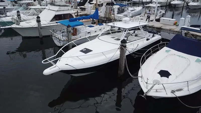 Slide: The Image of 2008 Intrepid 390 Sport Yacht docked at a marina, surrounded by other boats. - 8