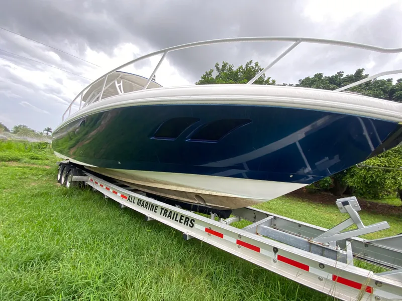Slide: The Image of 2008 Intrepid 390 Sport Yacht on trailer, parked on grass under cloudy sky. - 9
