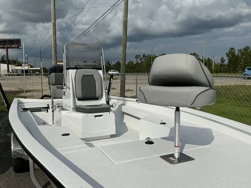 Slide: The Image of 2026 Xpress Hyper-Lift Series H22B boat with gray seating, parked outdoors. - 4