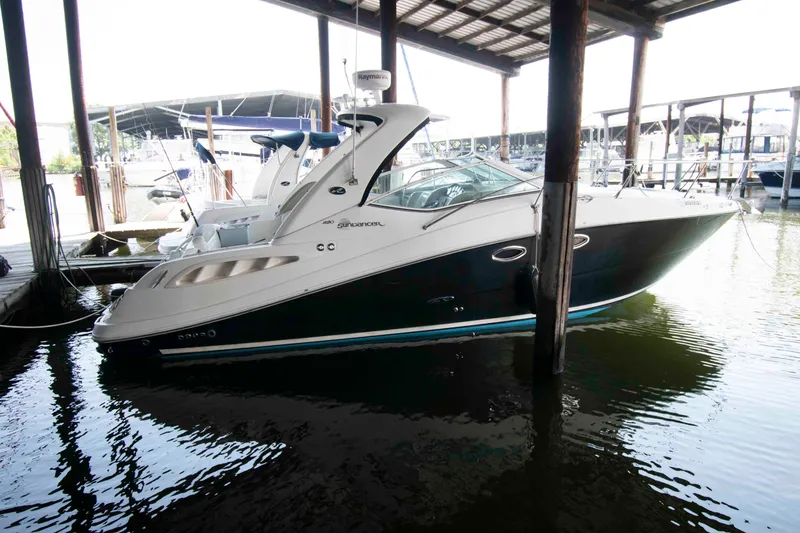 The Image of 2006 Sea Ray 290 Sundancer docked in a marina under a covered shelter. - 0