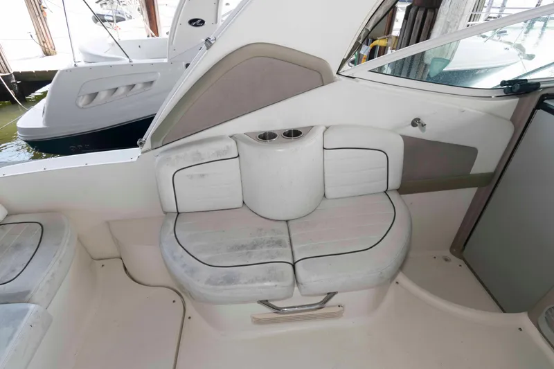Slide: The Image of 2006 Sea Ray 290 Sundancer boat interior with cushioned seating and cup holders. - 4