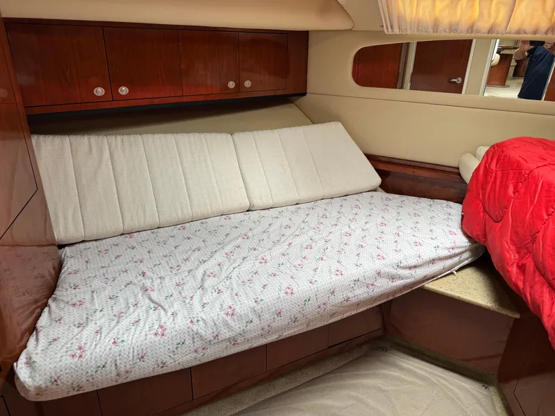 Slide: The Image of 2004 Sea Ray 390 Motoryacht cabin with bed, wooden cabinets, and red blanket. - 14