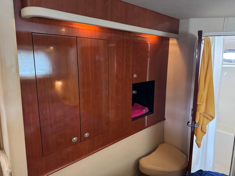 Slide: The Image of 2004 Sea Ray 390 Motoryacht interior with wooden cabinets and a small seating area. - 21