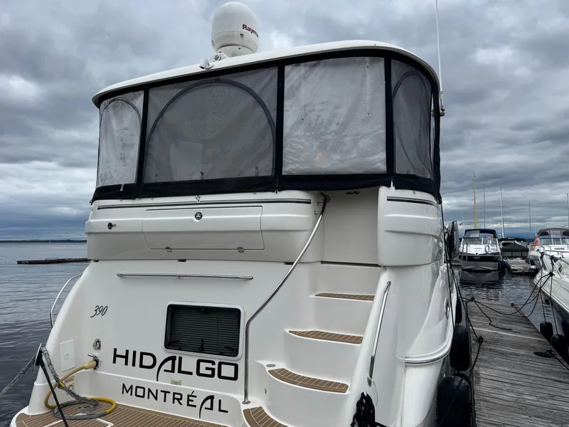 Slide: The Image of 2004 Sea Ray 390 Motoryacht docked, rear view with "Hidalgo Montréal" text. - 3