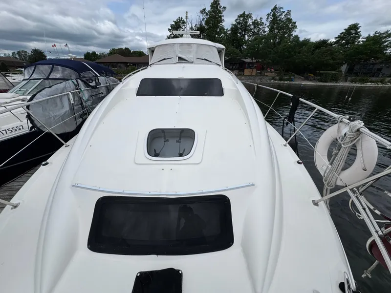 Slide: The Image of 2004 Sea Ray 390 Motoryacht docked, showcasing sleek white deck and marina surroundings. - 31