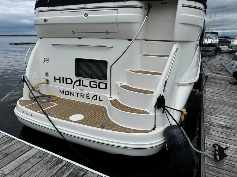Slide: The Image of 2004 Sea Ray 390 Motoryacht docked, featuring rear view with steps and "Hidalgo Montréal" text. - 4