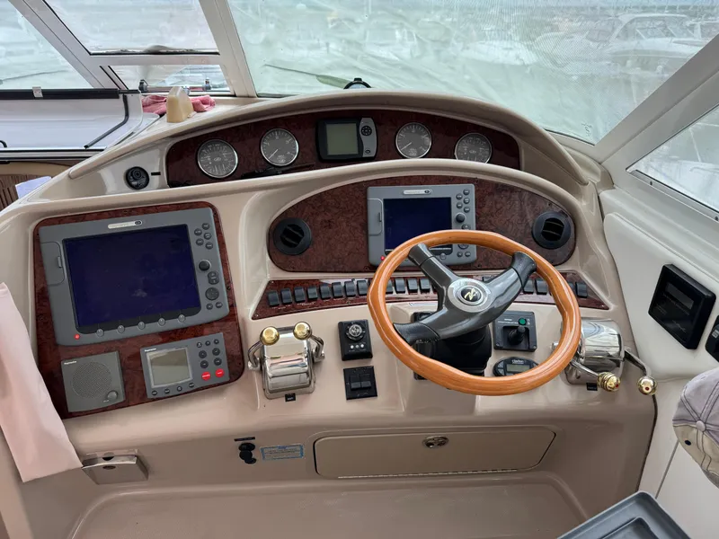 Slide: The Image of 2004 Sea Ray 390 Motoryacht helm with navigation instruments and wooden steering wheel. - 9