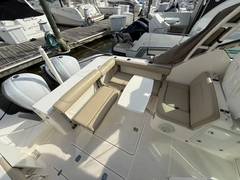 Slide: The Image of 2017 Pursuit DC 325 Dual Console boat interior with beige seating and white deck. - 20