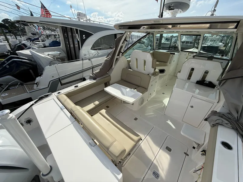 Slide: The Image of 2017 Pursuit DC 325 Dual Console boat interior with beige seating and white table. - 21