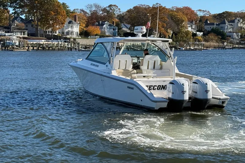 Slide: The Image of 2017 Pursuit DC 325 Dual Console boat cruising on a scenic waterfront. - 5