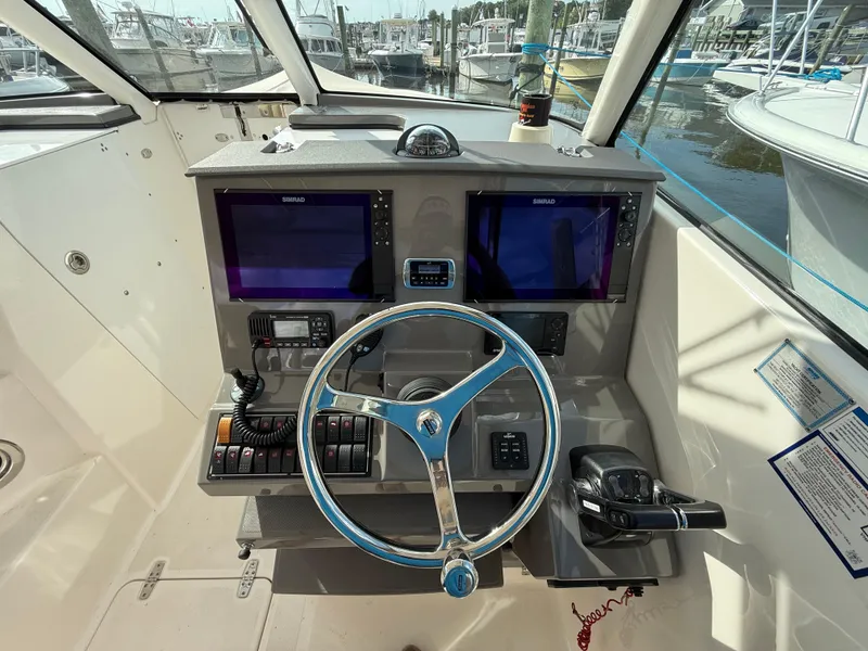 Slide: The Image of 2017 Pursuit DC 325 Dual Console helm with dual Simrad displays and modern controls. - 7