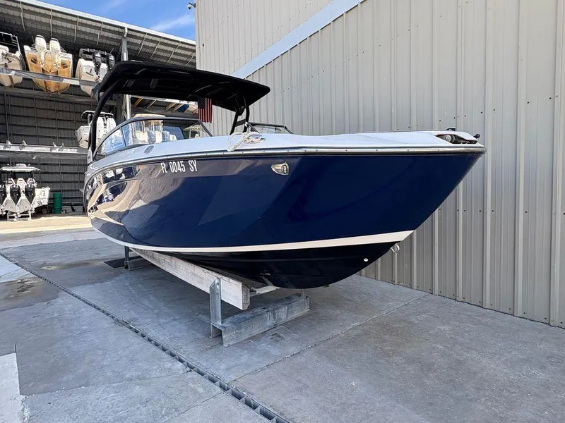The Image of 2021 Yamaha Boats 252SE in storage, blue hull, docked at marina. - 0