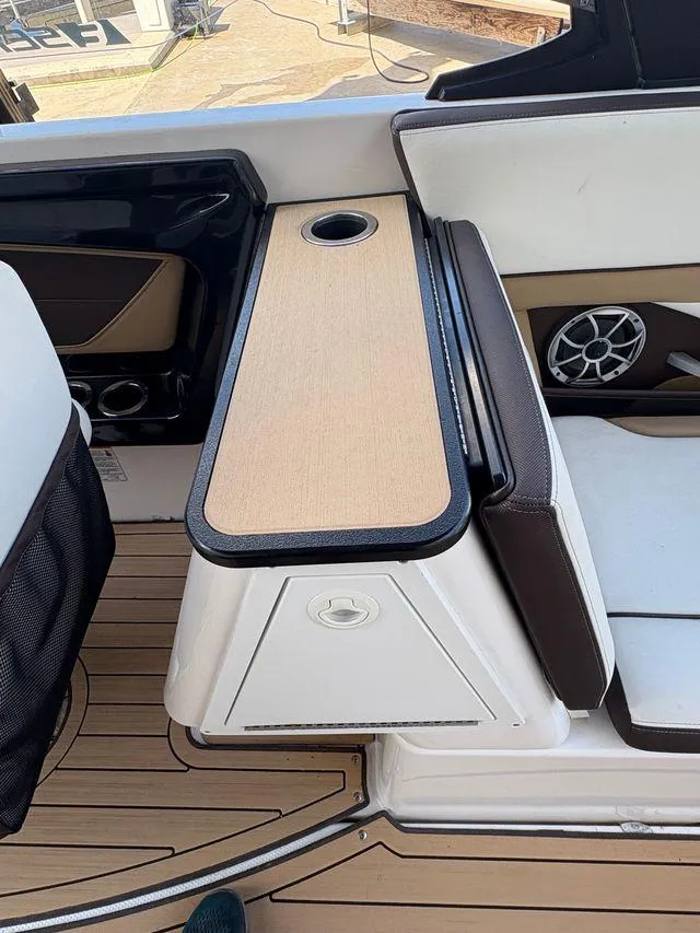 Slide: The Image of 2021 Yamaha Boats 252SE interior with seating and cup holder on deck. - 18