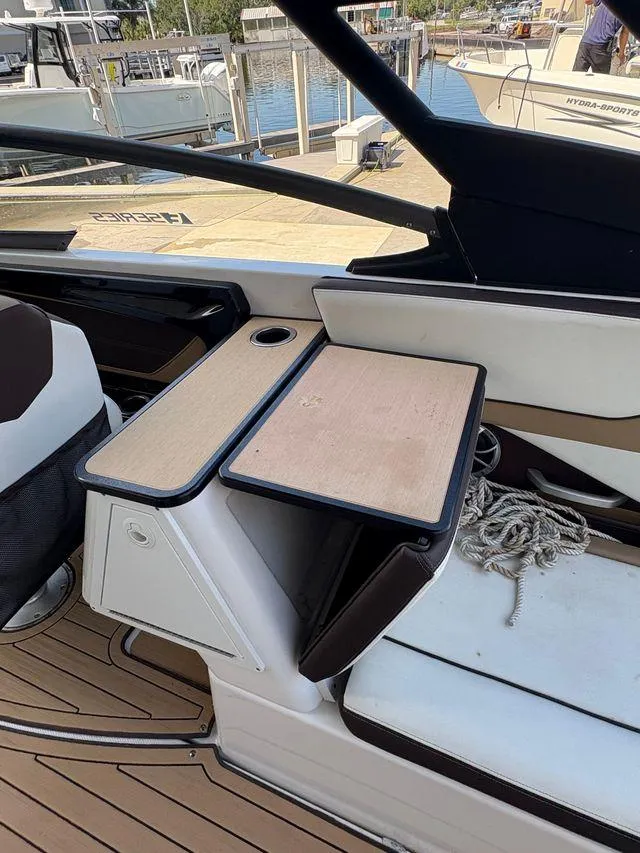 Slide: The Image of 2021 Yamaha Boats 252SE interior with seating, table, and rope on deck. - 19