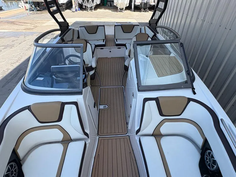 Slide: The Image of 2021 Yamaha Boats 252SE interior with tan and white seating, sleek design, and spacious layout. - 4
