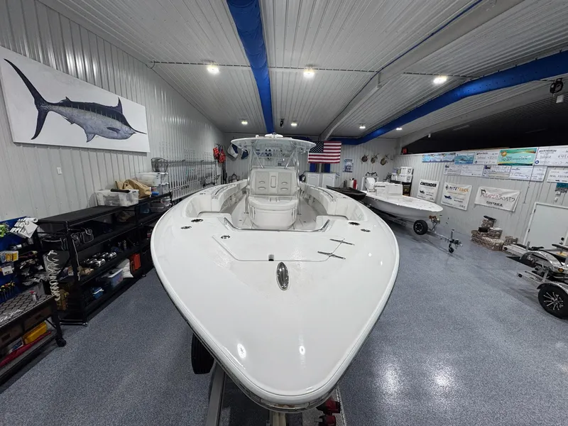 Slide: The Image of 2024 Contender 44 ST boat in showroom, surrounded by marine equipment and decor. - 10