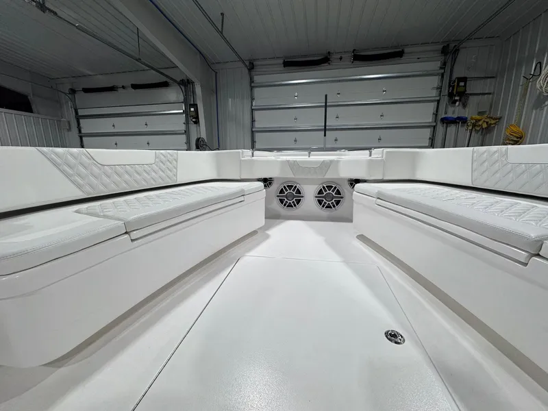 Slide: The Image of 2024 Contender 44 ST boat interior with white seating and speakers in a garage. - 25