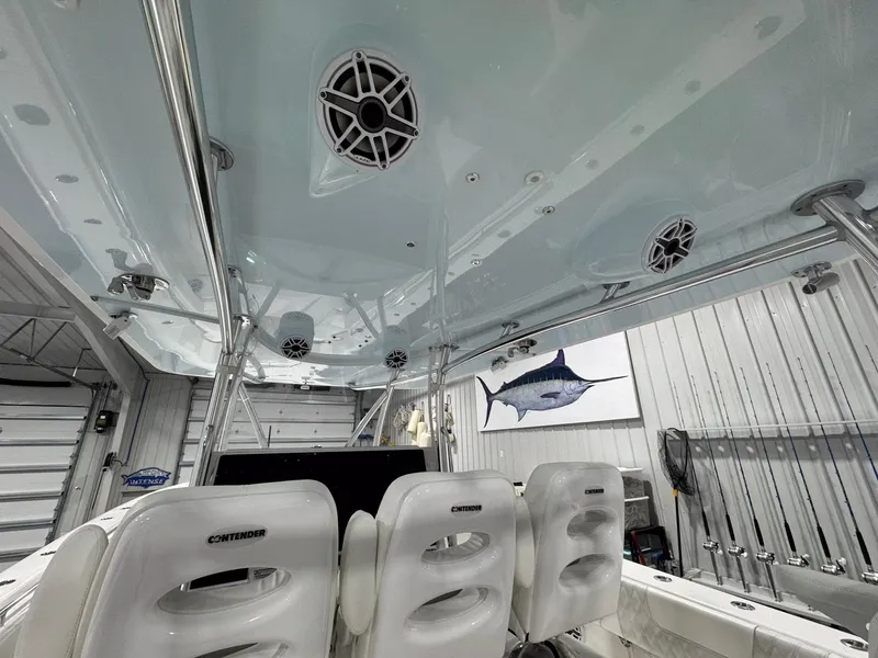 Slide: The Image of 2024 Contender 44 ST boat interior with speakers and fishing gear in a garage setting. - 38