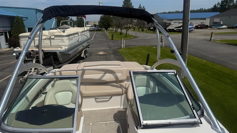 Slide: The Image of 2011 Chaparral 206 SSi boat with open bow, parked near other boats. - 15