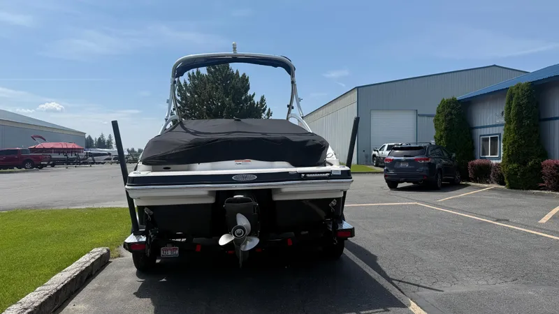Slide: The Image of 2011 Chaparral 206 SSi boat parked near industrial buildings on a sunny day. - 5
