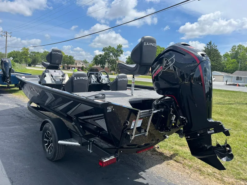 Slide: The Image of 2026 Lund 1875 Renegade SS boat with powerful outboard motor on a sunny day. - 2