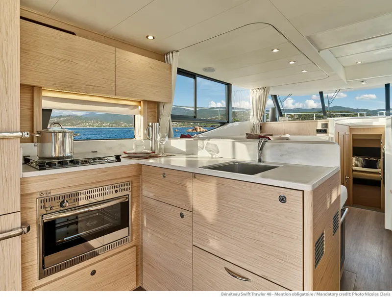 Slide: The Image of Modern kitchen interior of 2026 Beneteau Swift Trawler 48 yacht with scenic ocean view. - 14
