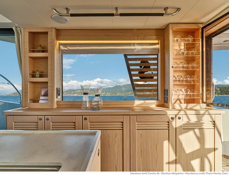 Slide: The Image of Interior of 2026 Beneteau Swift Trawler 48 with ocean view through window. - 15