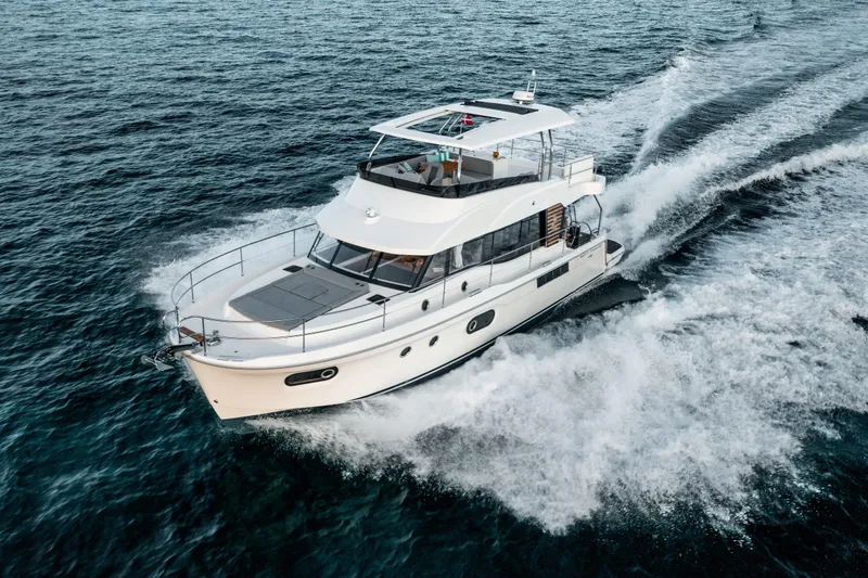 Slide: The Image of 2026 Beneteau Swift Trawler 48 cruising on open water, showcasing sleek design and performance. - 2