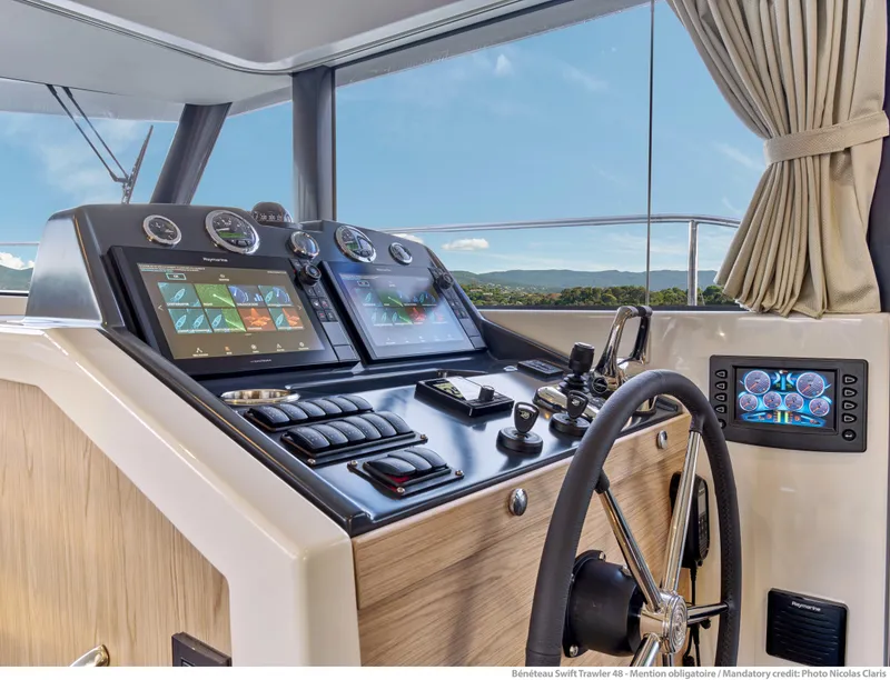 Slide: The Image of Helm of 2026 Beneteau Swift Trawler 48 with modern navigation displays and controls. - 22