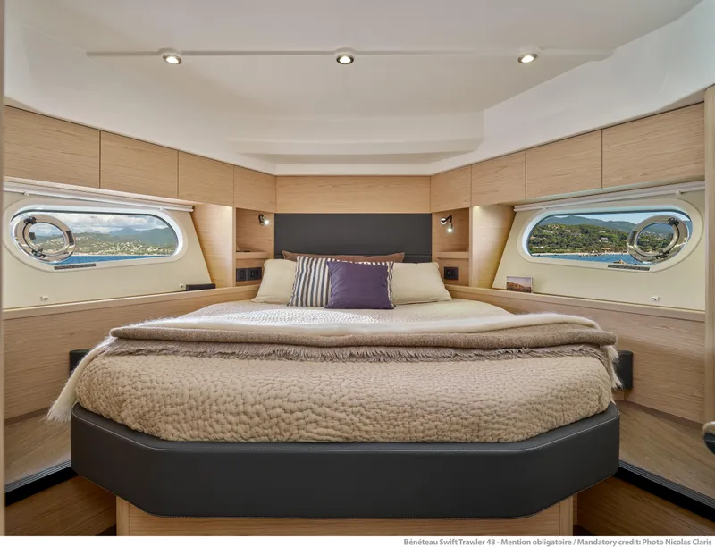 Slide: The Image of Luxurious bedroom interior of 2026 Beneteau Swift Trawler 48 with scenic window views. - 23