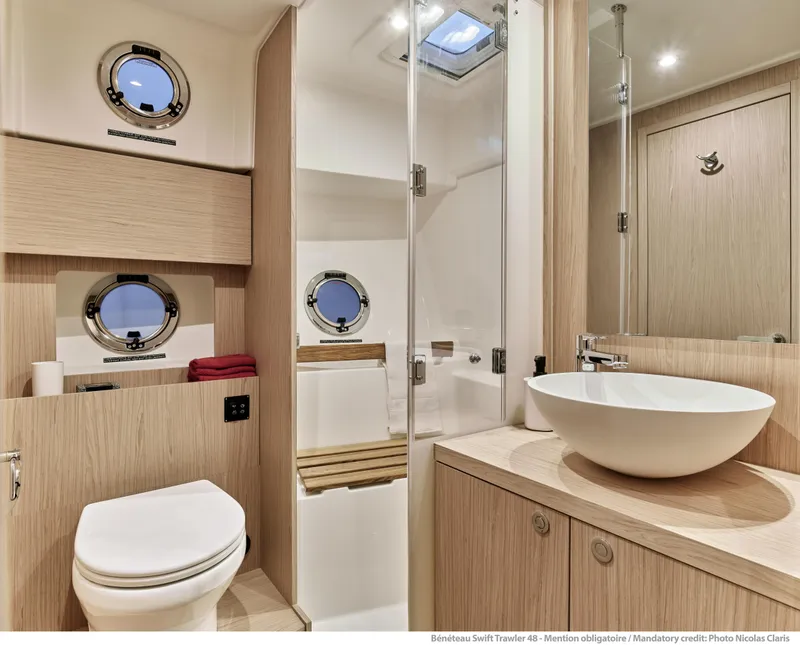 Slide: The Image of Luxurious bathroom in 2026 Beneteau Swift Trawler 48 with modern fixtures and porthole windows. - 25