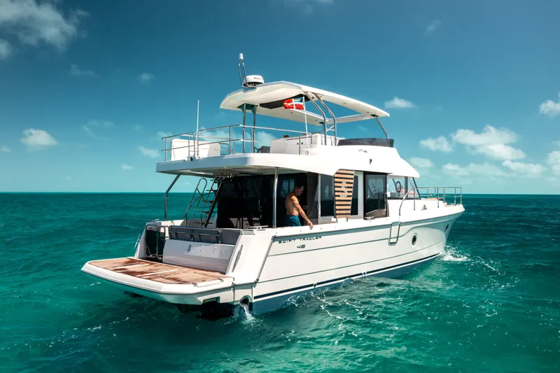 Slide: The Image of 2026 Beneteau Swift Trawler 48 cruising on turquoise ocean under clear blue sky. - 4