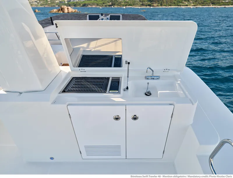 Slide: The Image of Outdoor kitchen on 2026 Beneteau Swift Trawler 48, featuring grill and sink, with ocean view. - 9